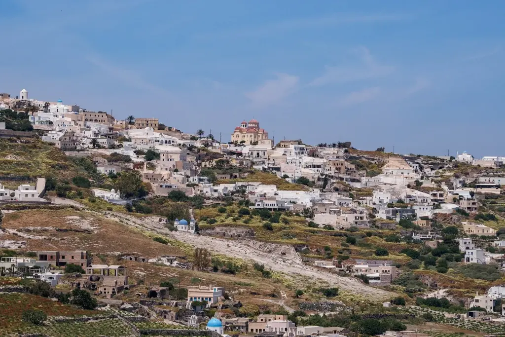The village of Exo Gonia spread across a green hillside with a domed church at its center