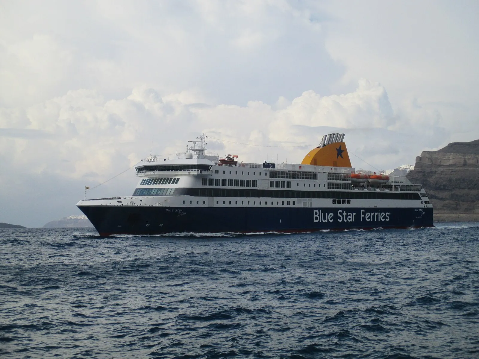 How to get to Santorini by sea: the Blue Star Delos ferry in Athinios bay below the caldera cliffs