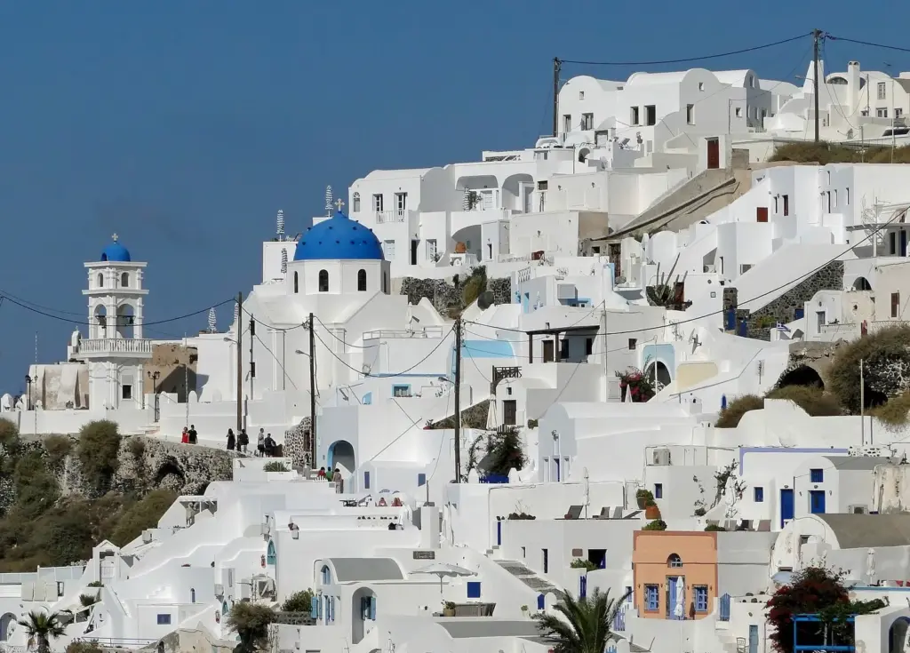 Whitewashed houses and a blue-domed church stepping down the caldera cliff in Imerovigli
