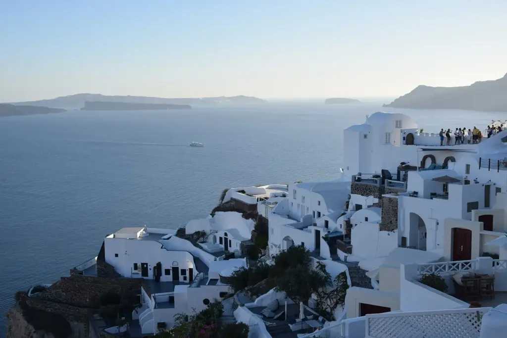 Whitewashed houses and hotel terraces stepping down the caldera cliff in Oia at dusk