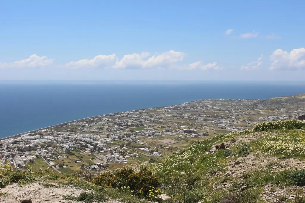 The flat southeast coast of Santorini with Perissa, Perivolos and Agios Georgios along the shore, seen from a hillside