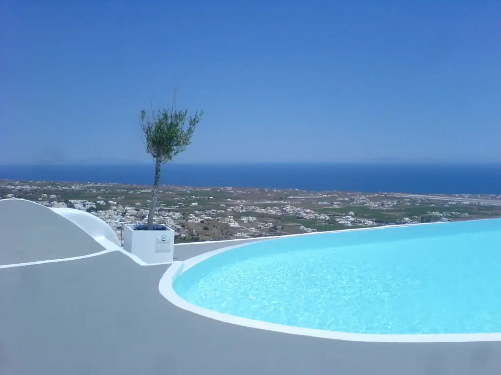 A hotel pool in Pyrgos looking east across Santorini's farmland to the open Aegean
