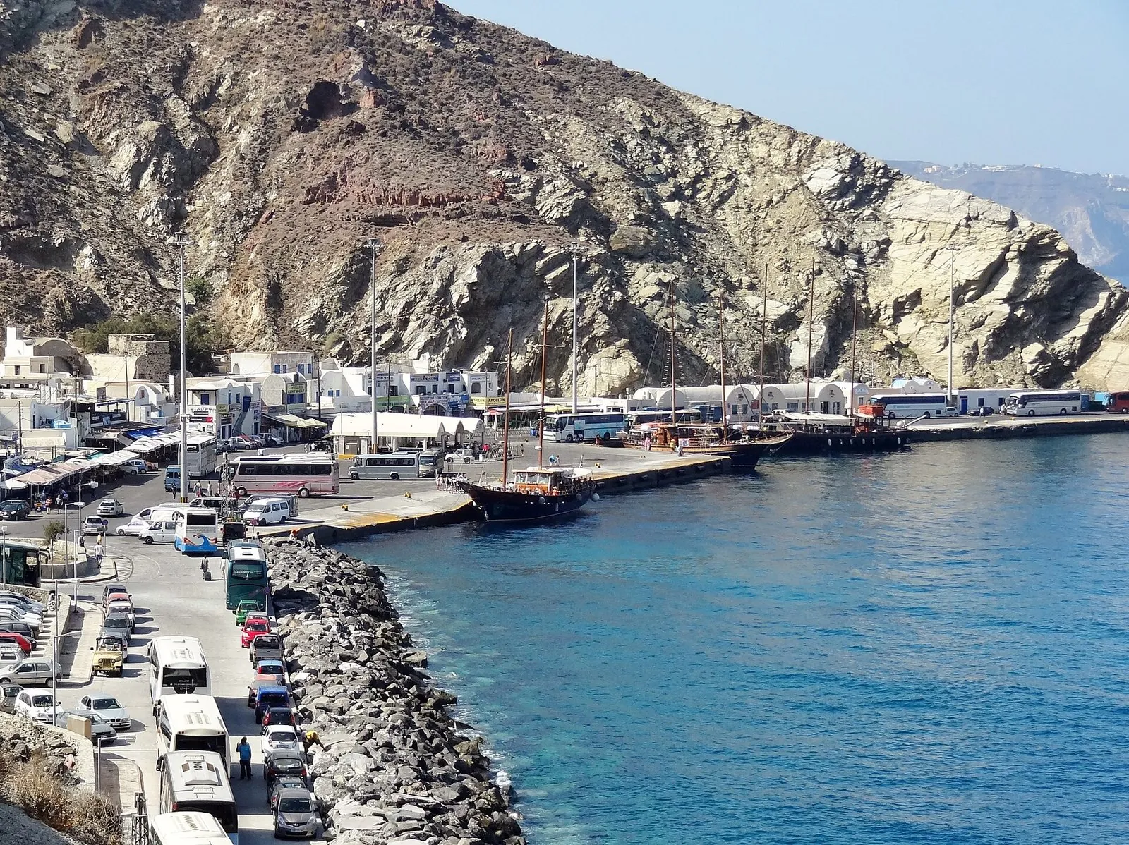 Santorini ferry port at Athinios from the cliff road, with buses, cars and boats along the quay