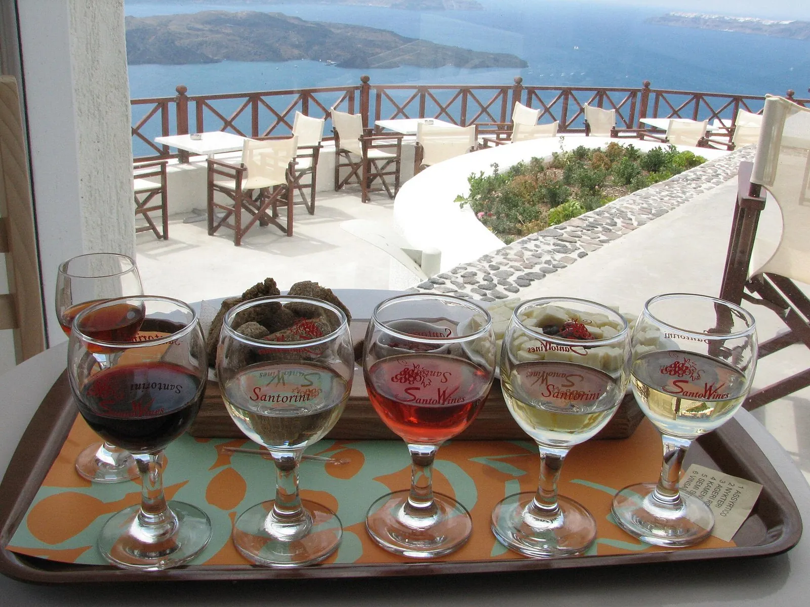 Santorini wineries: a tasting flight of white, rose and red Santorini wines on a terrace above the caldera