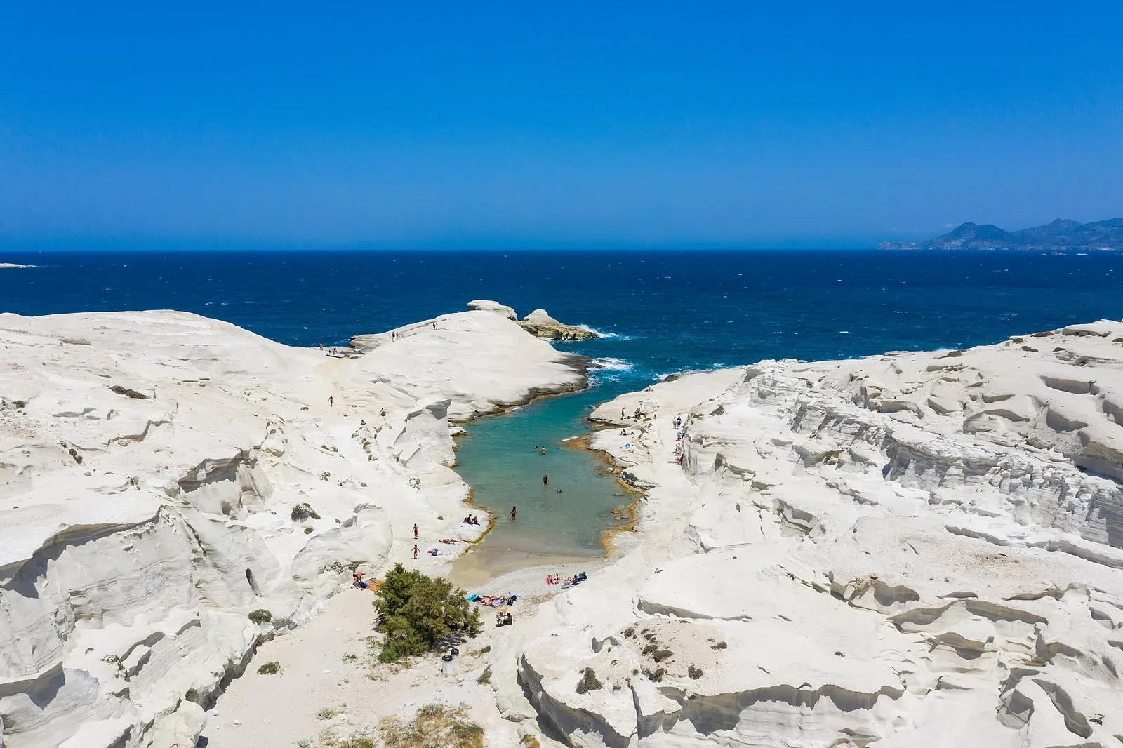White wave-carved volcanic rock around a turquoise inlet at Sarakiniko on Milos, one of the best Greek islands for beaches