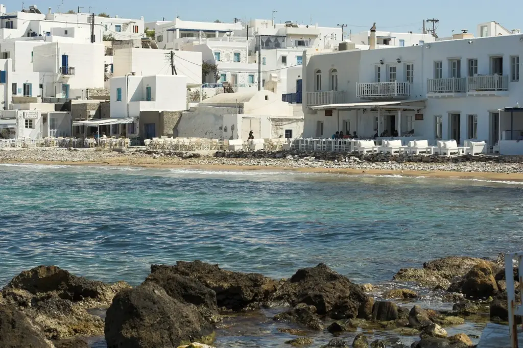 White houses lining the clear turquoise water of a small harbor at Naoussa on Paros
