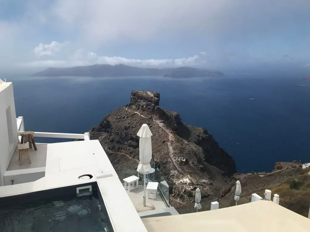 Skaros rock jutting into the deep blue caldera below whitewashed terraces in Imerovigli
